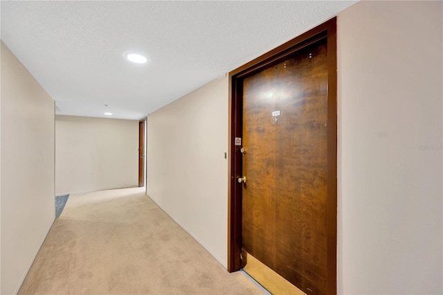 hall with recessed lighting and light colored carpet