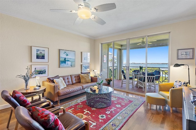 living area featuring ceiling fan, wood finished floors, and ornamental molding