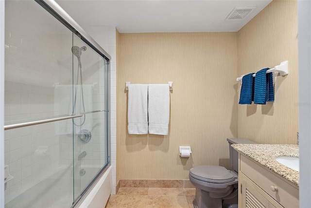 bathroom featuring visible vents, toilet, shower / bath combination with glass door, tile patterned flooring, and vanity