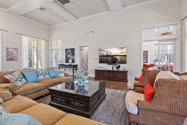 living area with wood finished floors, a healthy amount of sunlight, visible vents, and baseboards