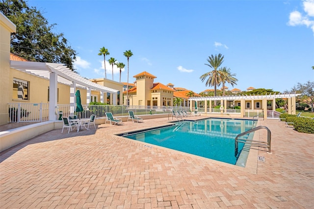 pool featuring a patio, fence, and a pergola