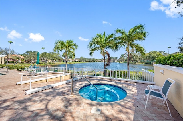 view of pool featuring a community hot tub, a patio, and a water view