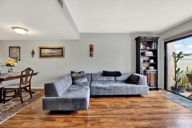 living area featuring visible vents and wood finished floors