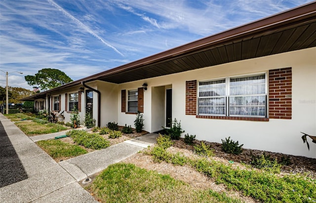 view of front of house featuring brick siding and stucco siding