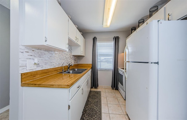 kitchen featuring a sink, tasteful backsplash, white appliances, white cabinets, and light tile patterned floors