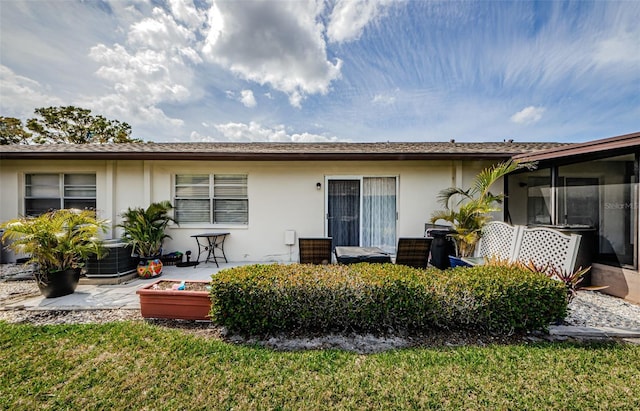 back of property with a patio and stucco siding