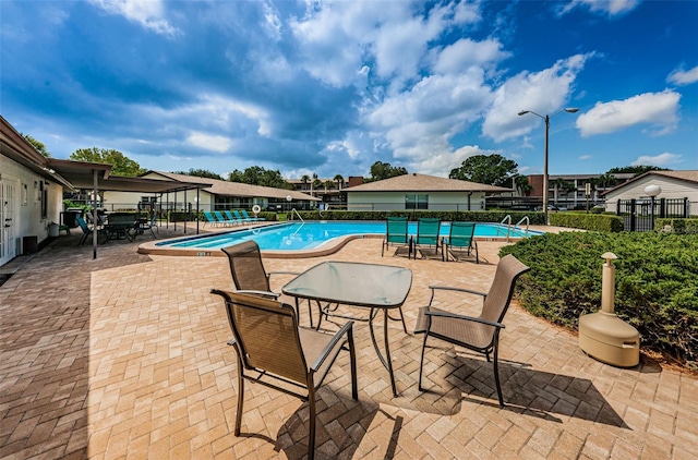 community pool featuring a patio and fence