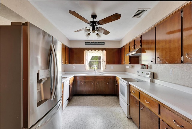 kitchen featuring white appliances, visible vents, a sink, light countertops, and under cabinet range hood