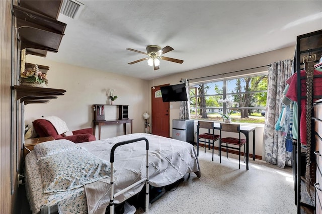 bedroom with speckled floor, visible vents, and ceiling fan