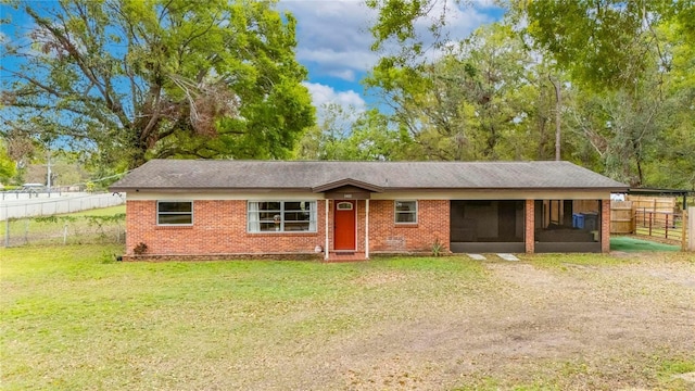 ranch-style home with a sunroom, brick siding, a front lawn, and fence