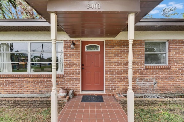 doorway to property featuring brick siding