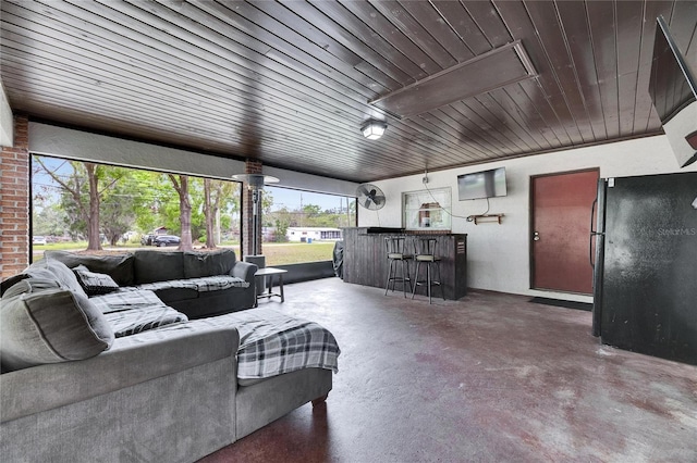 living room with a bar, concrete floors, and attic access