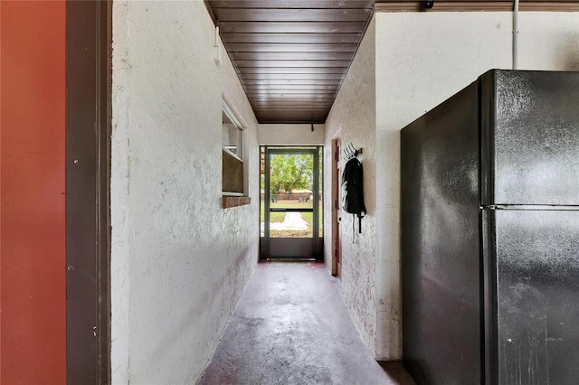 corridor with concrete floors and a textured wall