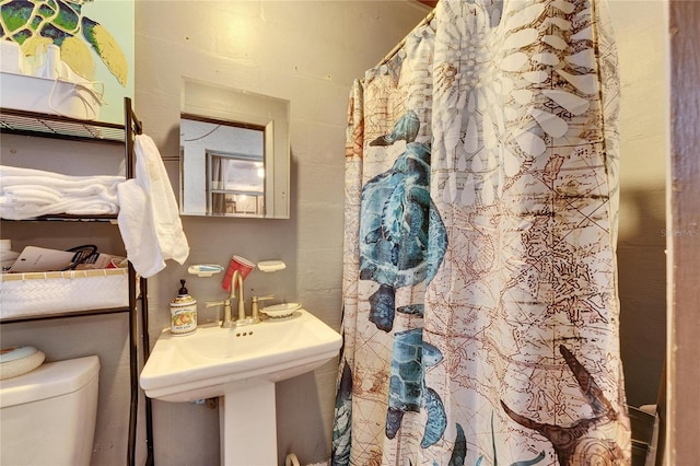 bathroom with toilet, a shower with curtain, and a sink