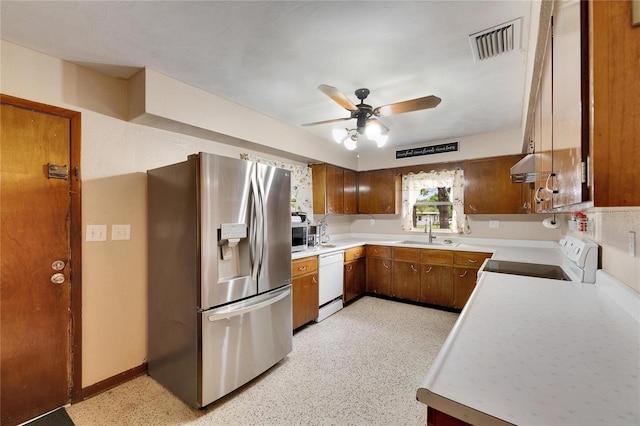 kitchen featuring brown cabinetry, visible vents, a sink, light countertops, and appliances with stainless steel finishes