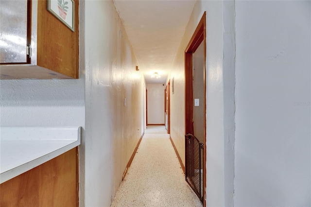 hallway featuring light speckled floor