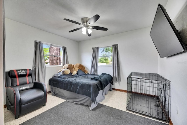 bedroom with multiple windows, a ceiling fan, and baseboards