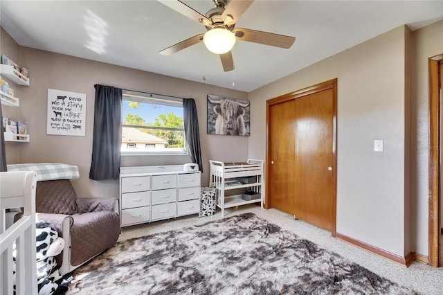 carpeted bedroom featuring a closet, baseboards, and ceiling fan