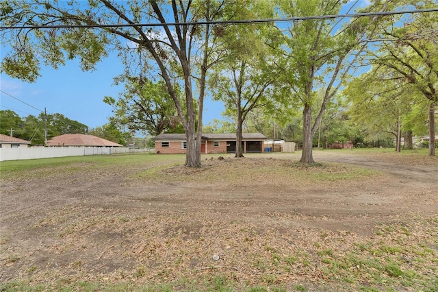 ranch-style house featuring fence