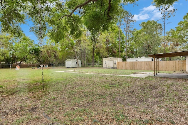 view of yard with an outbuilding, a fenced backyard, and a shed