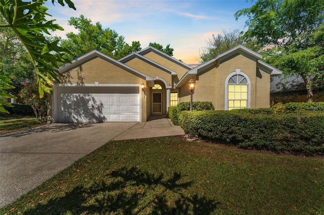 ranch-style house featuring stucco siding, an attached garage, and driveway