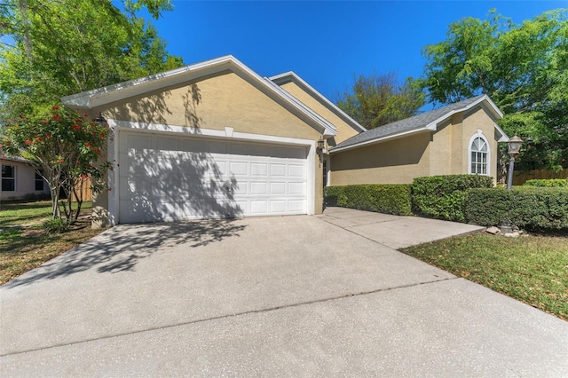 view of front of property with stucco siding, an attached garage, and concrete driveway