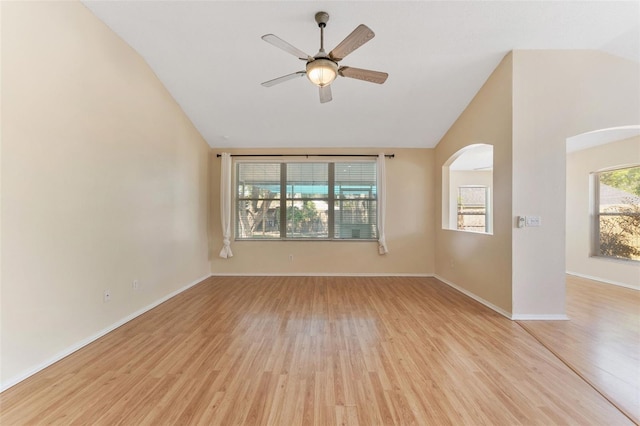 spare room featuring lofted ceiling, arched walkways, a ceiling fan, and light wood finished floors