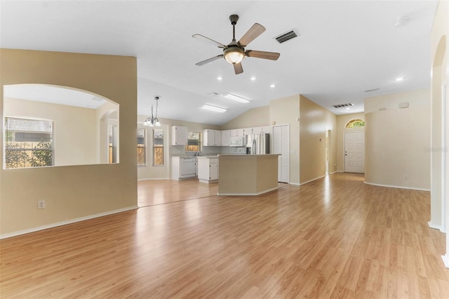 unfurnished living room with visible vents, light wood-style flooring, arched walkways, lofted ceiling, and ceiling fan