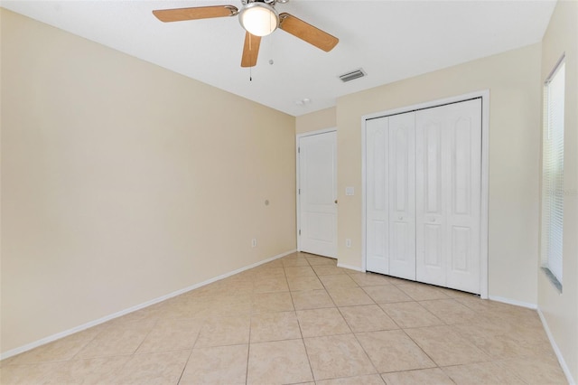 unfurnished bedroom featuring visible vents, a ceiling fan, a closet, light tile patterned flooring, and baseboards