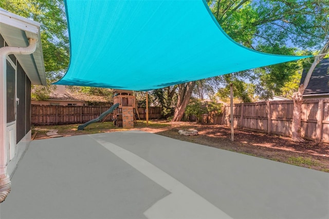 view of patio / terrace with a playground and a fenced backyard