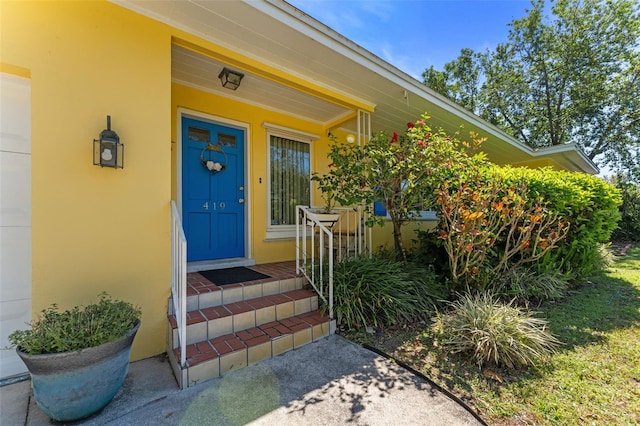 entrance to property featuring stucco siding