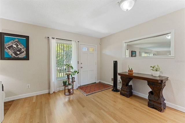 entryway with wood finished floors and baseboards