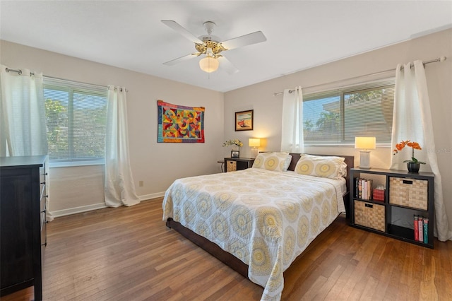 bedroom with hardwood / wood-style floors, multiple windows, and baseboards