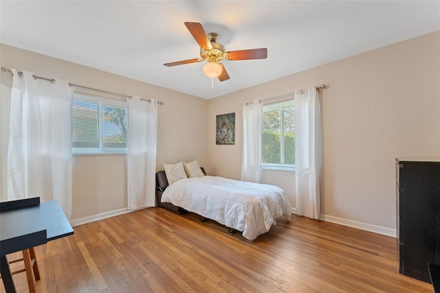 bedroom featuring light wood-type flooring, baseboards, and ceiling fan