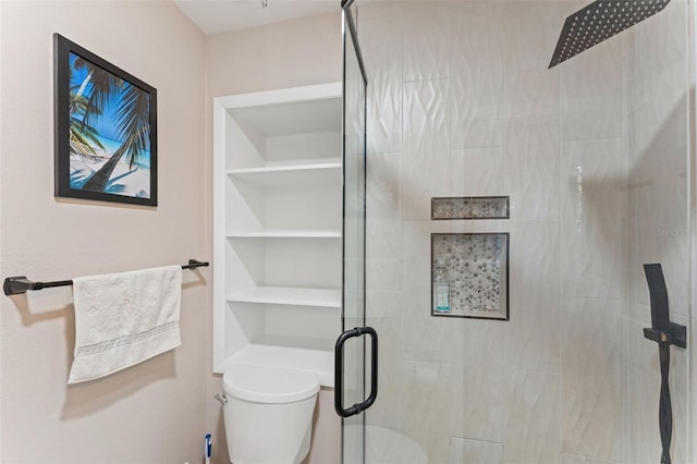 full bath featuring a stall shower, toilet, and built in shelves