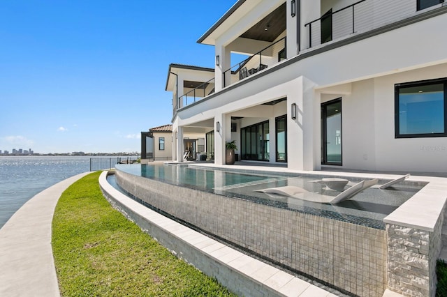 view of pool with a patio, a water view, and an infinity pool