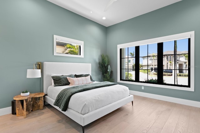 bedroom with recessed lighting, wood finished floors, and baseboards