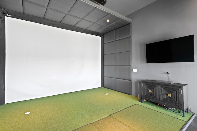 recreation room with carpet floors and golf simulator