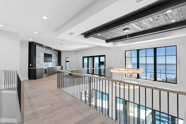 hallway with visible vents, beam ceiling, an upstairs landing, wood finished floors, and recessed lighting