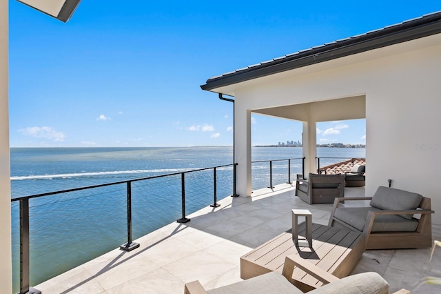 view of patio / terrace with outdoor lounge area, a balcony, and a water view