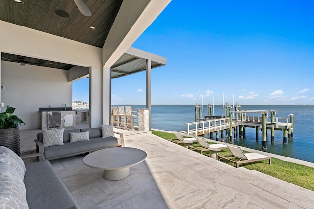 view of patio / terrace featuring a water view, boat lift, a dock, and outdoor lounge area