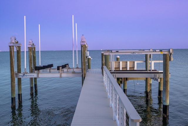 dock area featuring boat lift and a water view