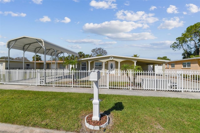 view of front of property with a detached carport, a front yard, and a fenced front yard