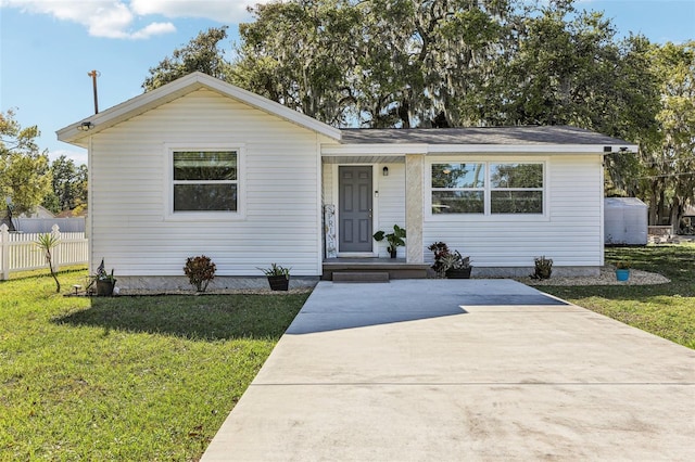 view of front of house with a front yard and fence