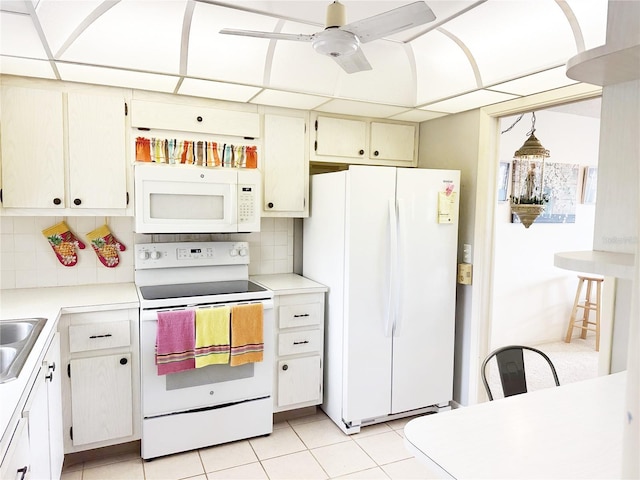 kitchen featuring white appliances, a ceiling fan, a sink, light countertops, and backsplash