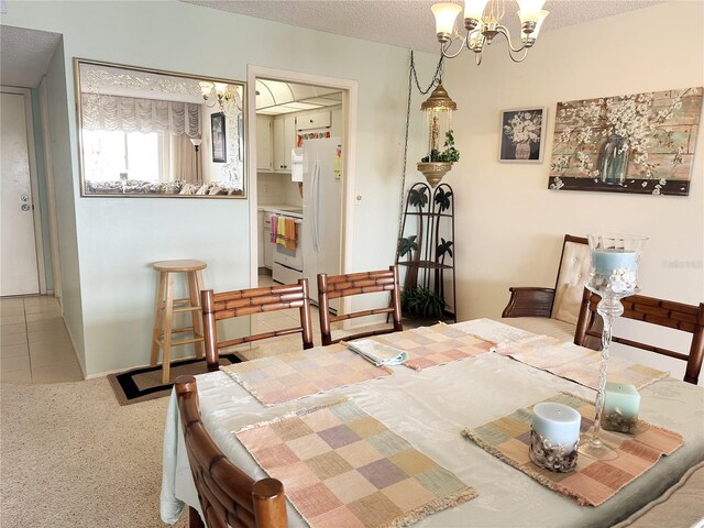 tiled dining space featuring a notable chandelier, carpet floors, and a textured ceiling