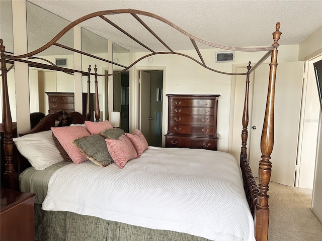 bedroom featuring carpet flooring, visible vents, and a textured ceiling