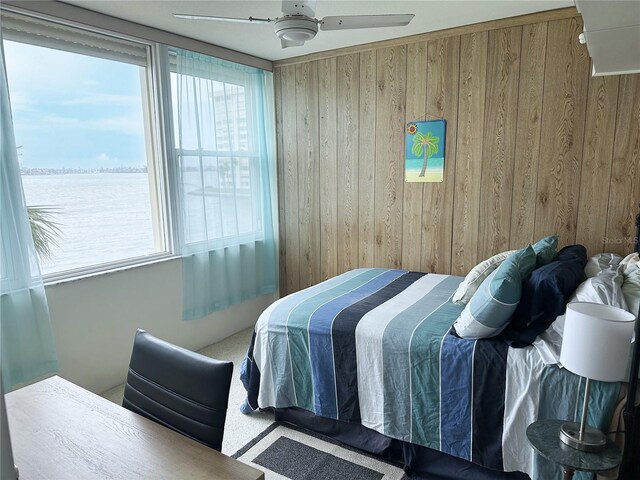 bedroom featuring wooden walls and a ceiling fan