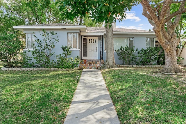 ranch-style home featuring a front yard and stucco siding