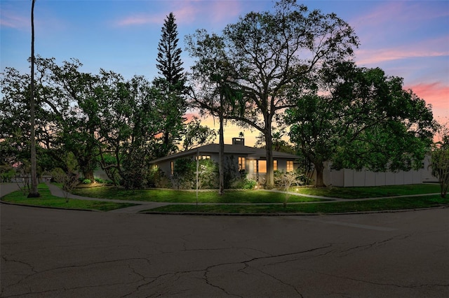 view of front of property featuring a lawn and a chimney